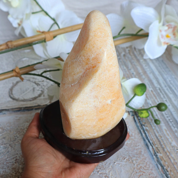 Large Orange Calcite Stone: Free Form Decor on Wooden Stand
