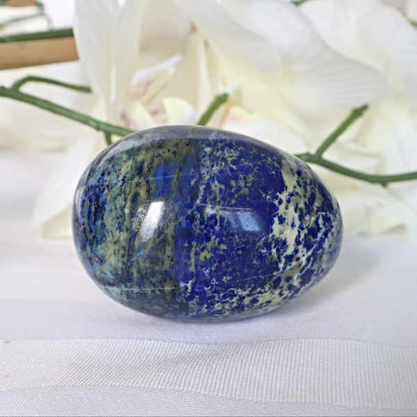 Side view of a natural blue Lapis Lazuli egg showing white calcite veining