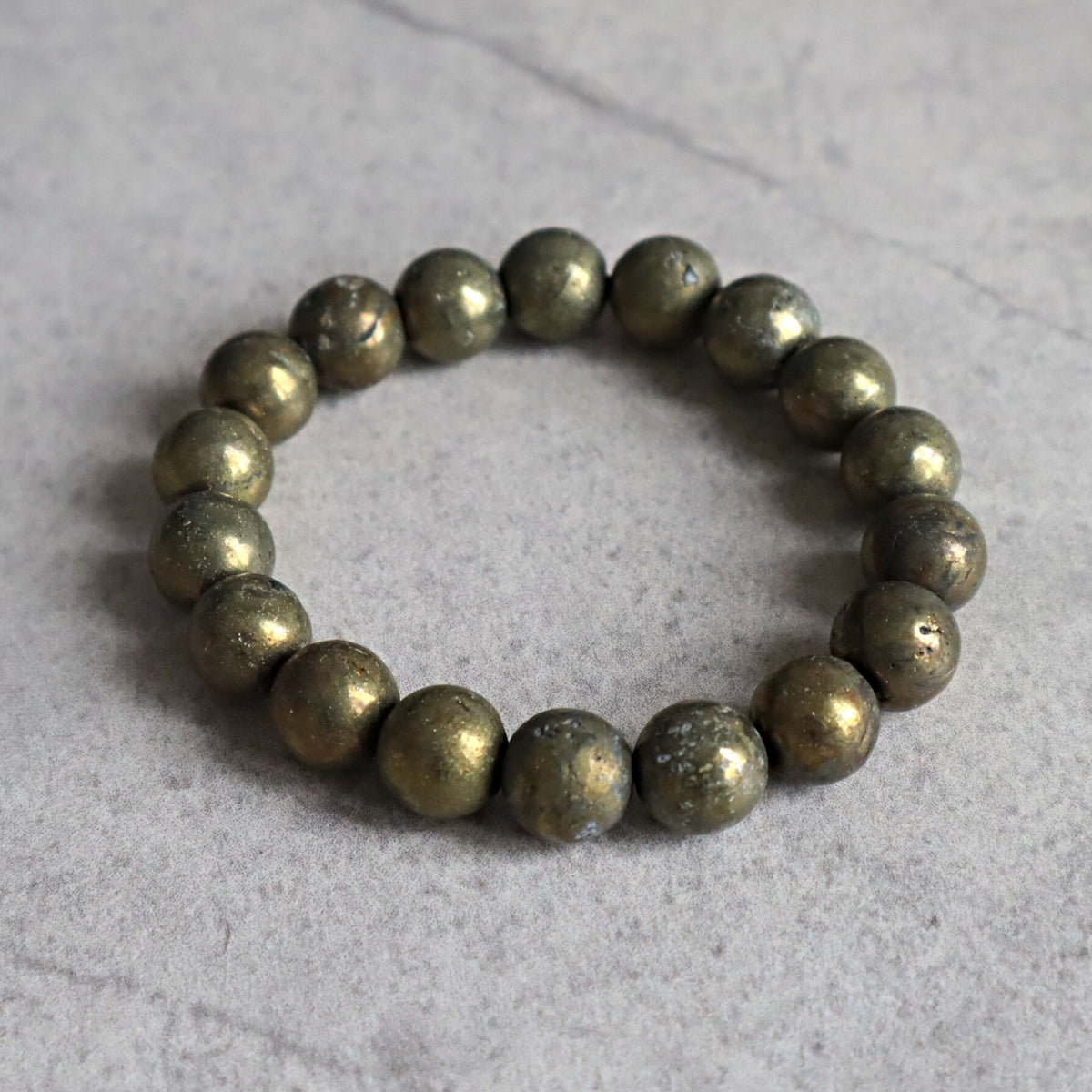 Close up of genuine iron pyrite beads highlighting natural mineral imperfections and shine.
