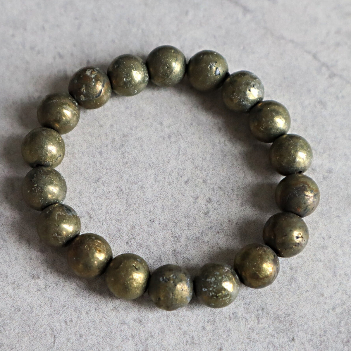 Close up of genuine iron pyrite beads highlighting natural mineral imperfections and shine.