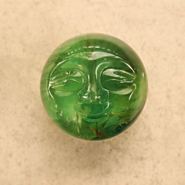 Carved fluorite moon face sphere for lunar healing and intuition