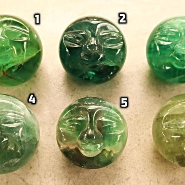Fluorite crystal orb with moon face design for spiritual energy