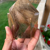Smoky rutilated quartz tower with golden rutile