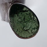 Dual sided moldavite pendant raw and polished view
