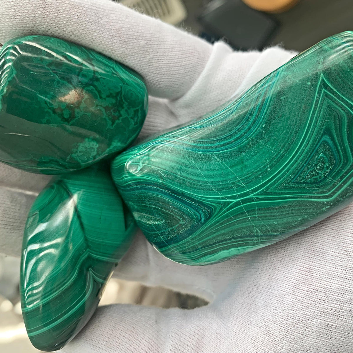 Ethically sourced raw malachite gemstone polished into a smooth organic freeform shape.