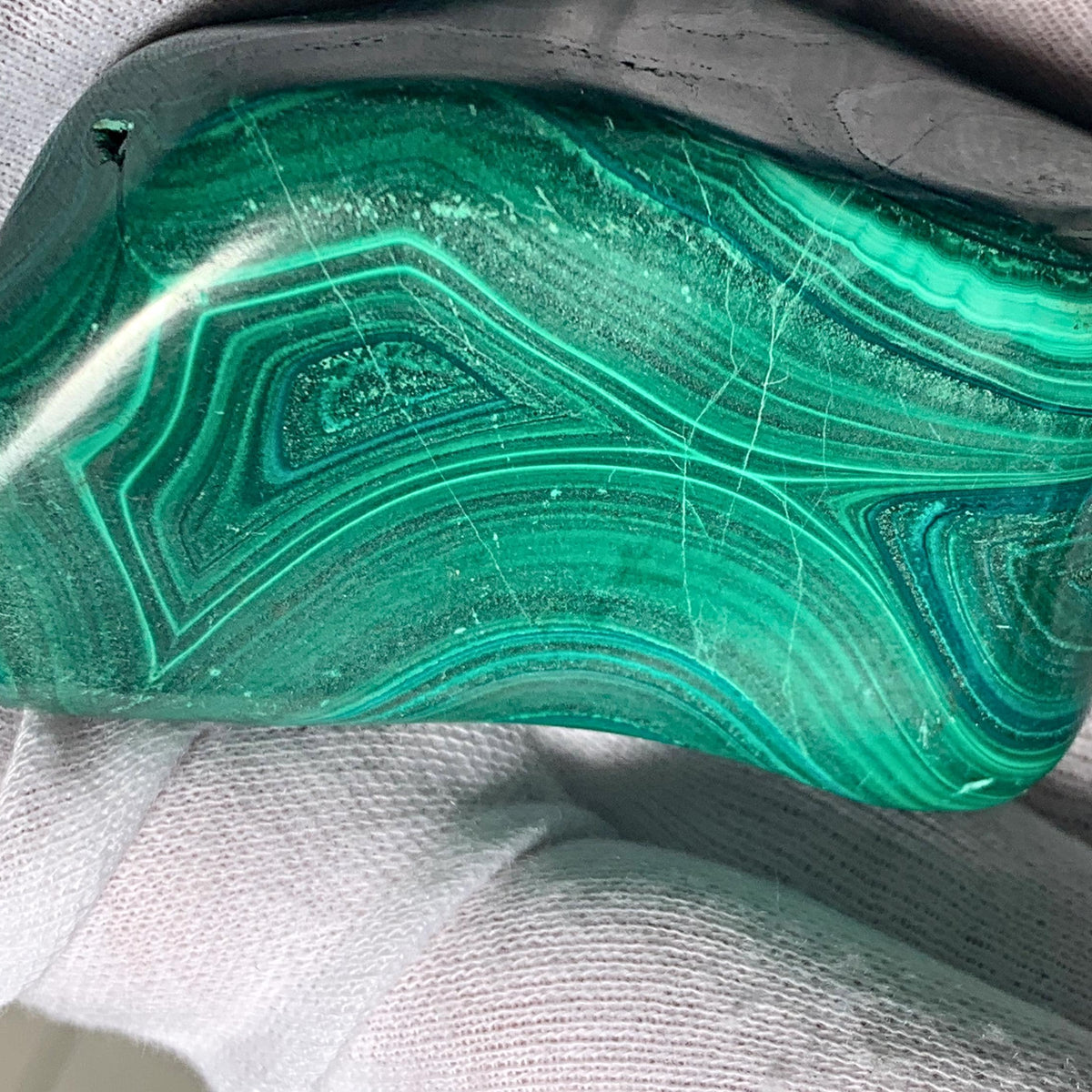 Genuine malachite stone featuring characteristic velvet-like green stripes and swirls.