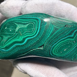 Genuine malachite stone featuring characteristic velvet-like green stripes and swirls.