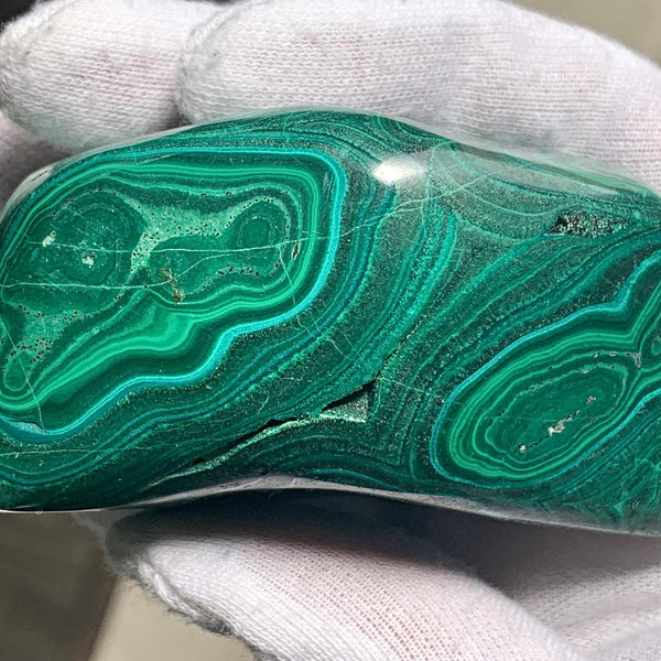 Genuine malachite stone featuring characteristic velvet-like green stripes and swirls.