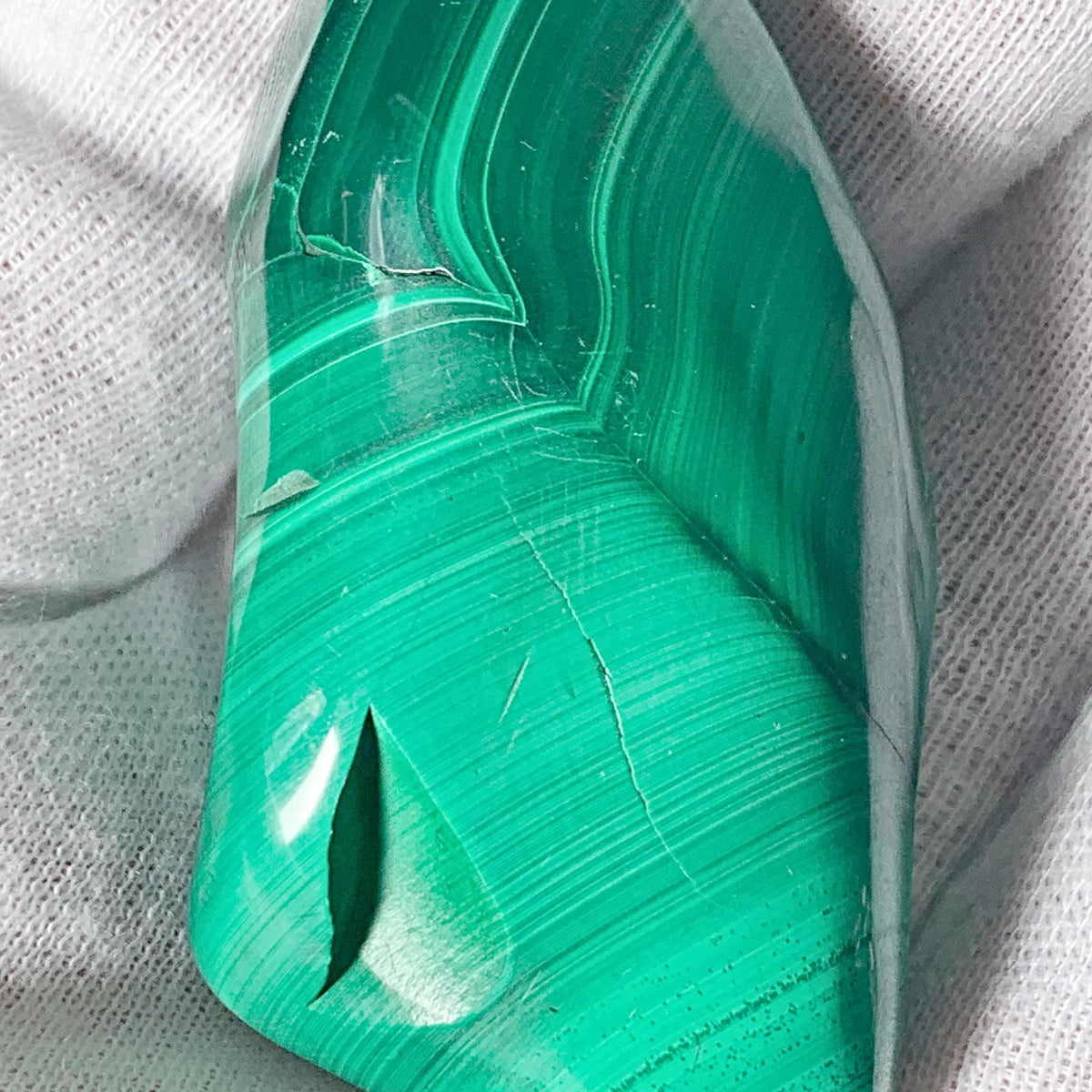 Ethically sourced raw malachite gemstone polished into a smooth organic freeform shape.