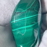 Ethically sourced raw malachite gemstone polished into a smooth organic freeform shape.
