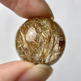 Natural rutilated quartz sphere with golden rutile inclusions