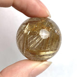 Rutilated quartz sphere with golden rutile needles