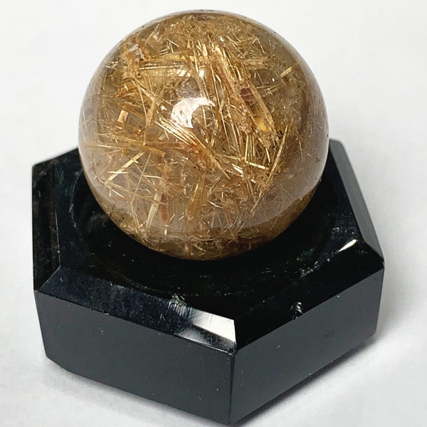 Rutilated quartz sphere with golden rutile needles