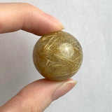 Rutilated quartz sphere with golden rutile needles