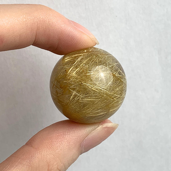 Rutilated quartz sphere with golden rutile needles