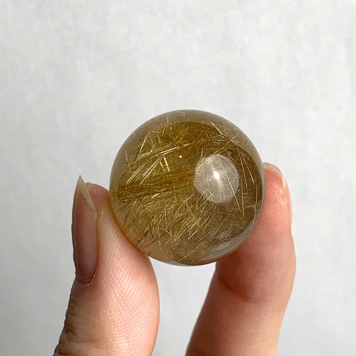 Natural rutilated quartz mineral sphere