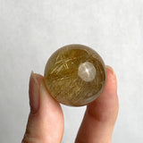 Natural rutilated quartz mineral sphere