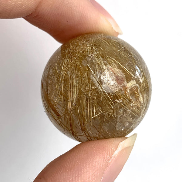 Rutilated quartz sphere with golden rutile needles