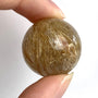 Rutilated quartz sphere with golden rutile needles