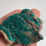 sparkling emerald dioptase crystals on rock