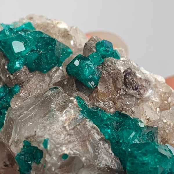 vivid green dioptase crystals on natural rock
