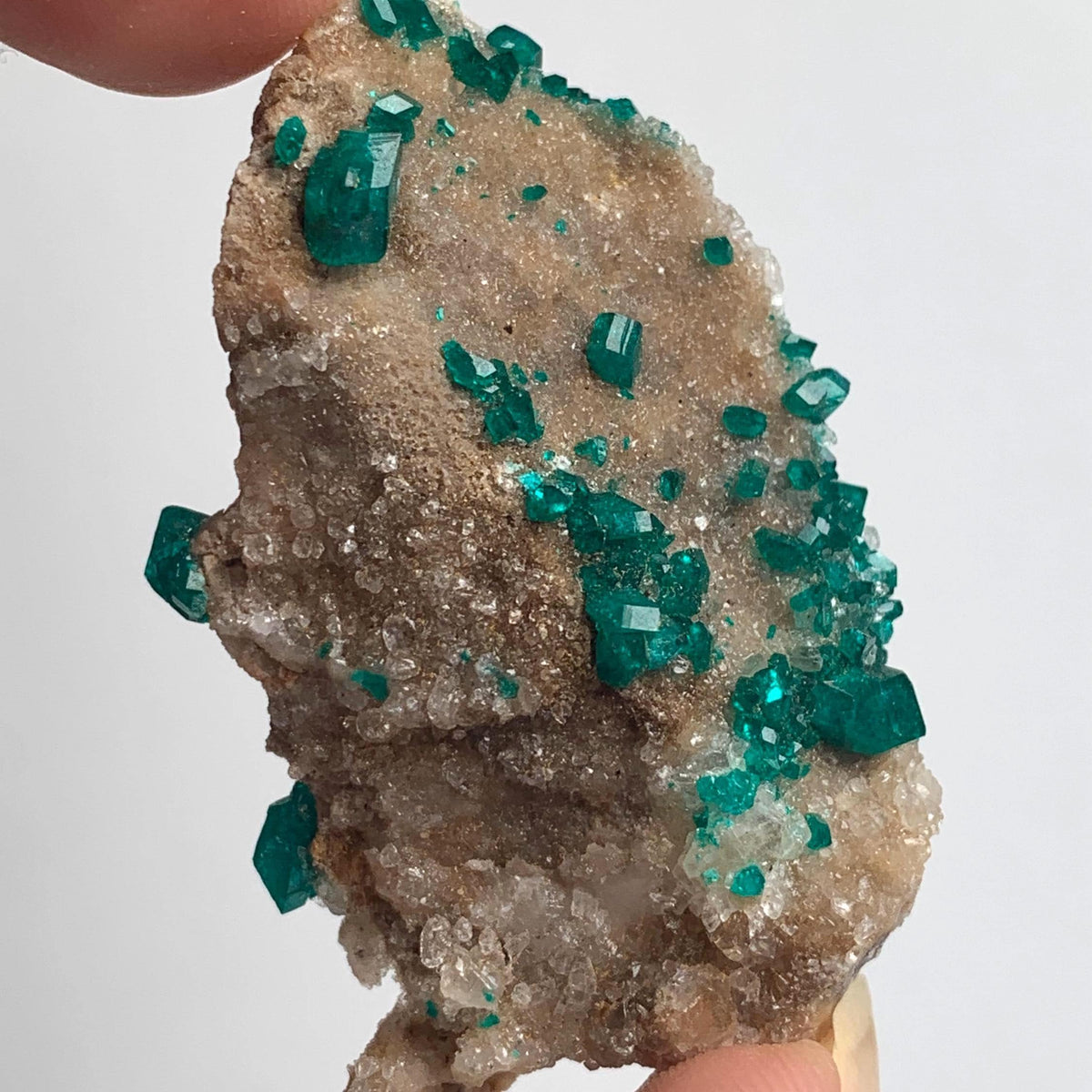 green dioptase crystals across natural matrix