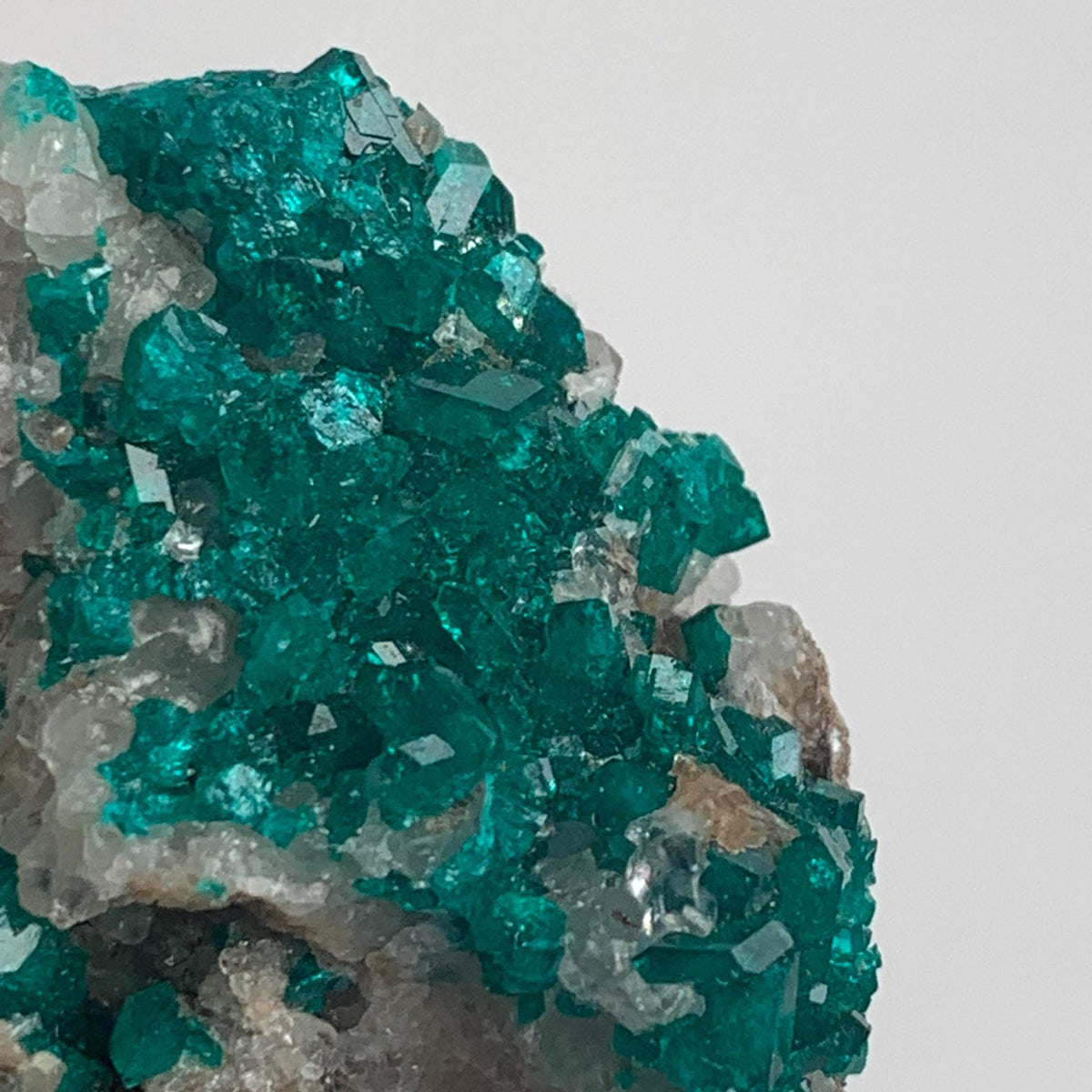bright green dioptase crystals on natural matrix