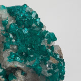 bright green dioptase crystals on natural matrix