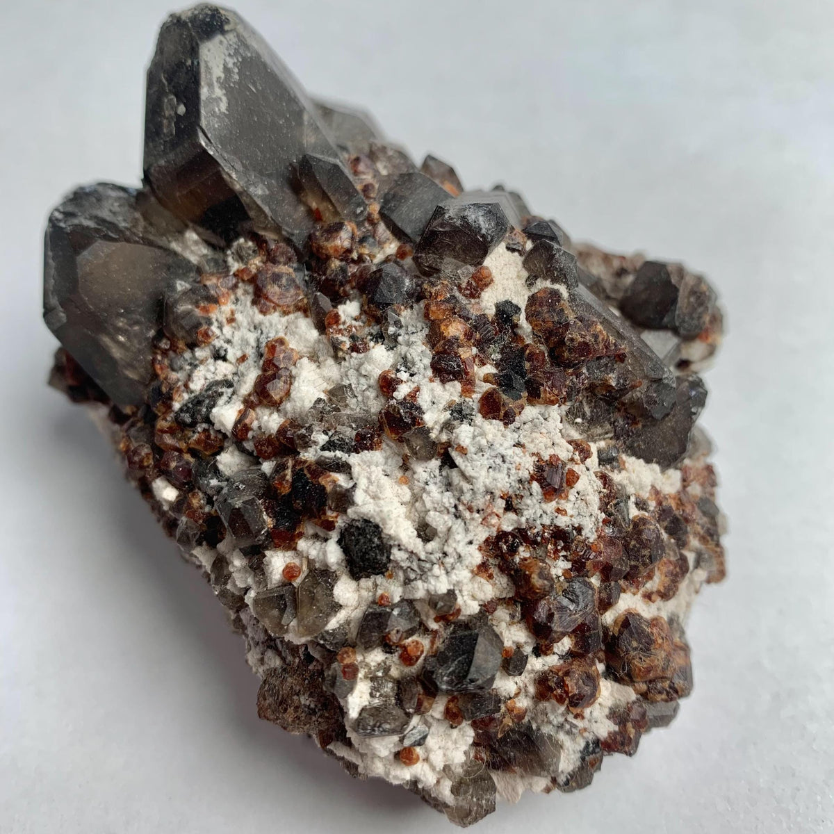 Red garnet crystals with smoky quartz cluster display