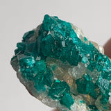 vivid green dioptase crystals on natural rock