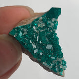 vivid green dioptase crystal coating on rock