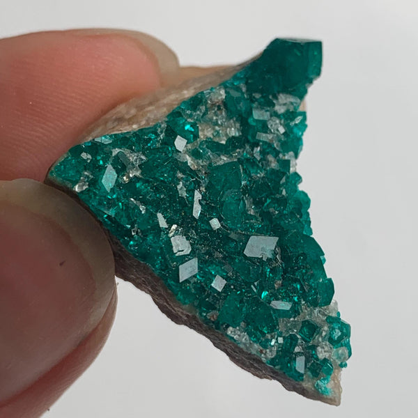 vivid green dioptase crystal coating on rock