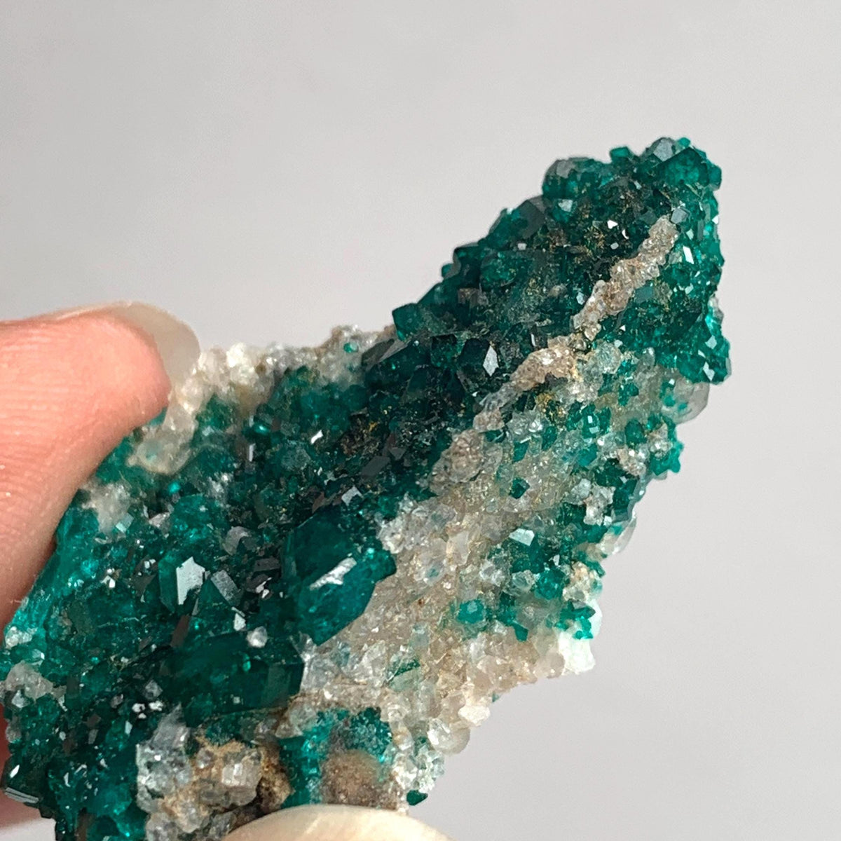 vivid green dioptase crystals on rock matrix