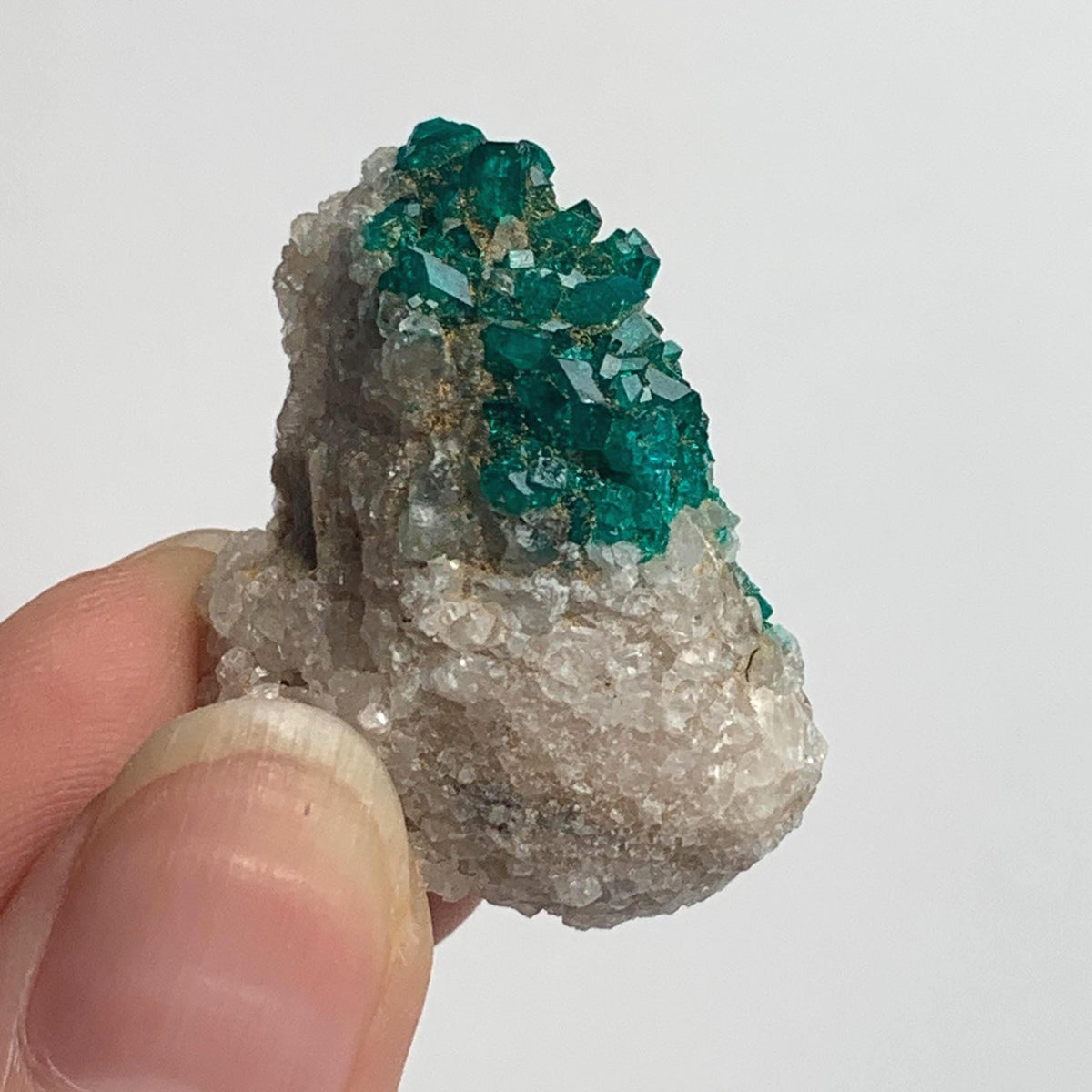 green dioptase crystals clustered on host rock