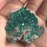 vivid green dioptase crystals on both sides rock