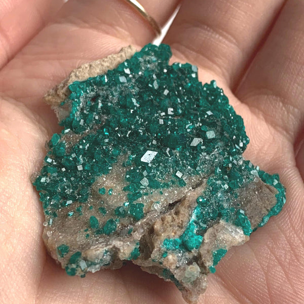 vivid green dioptase crystals on both sides rock