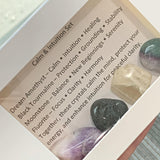 Calming crystals sets displayed inside open cardboard gift boxes with properties cards