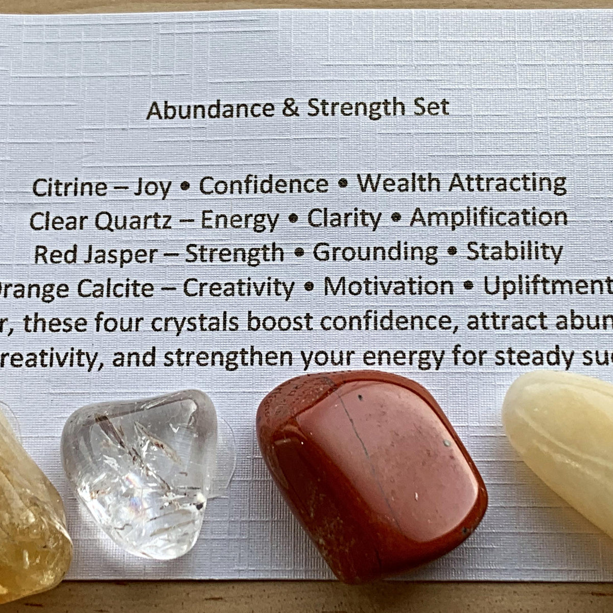 Abundance and wealth themed crystal sets displayed inside open cardboard gift boxes with properties cards