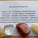 Abundance and wealth themed crystal sets displayed inside open cardboard gift boxes with properties cards