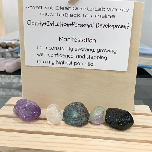 Violet amethyst cluster and flashy labradorite crystal placed beside a personal growth affirmation note