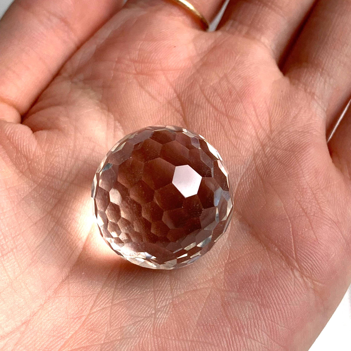 Flawless 25mm clear quartz micro faceted sphere reflecting brilliant light