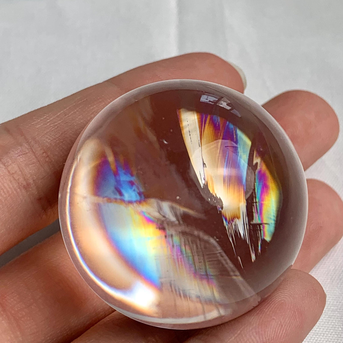Small rainbow quartz sphere with natural rainbow inclusions and polished finish