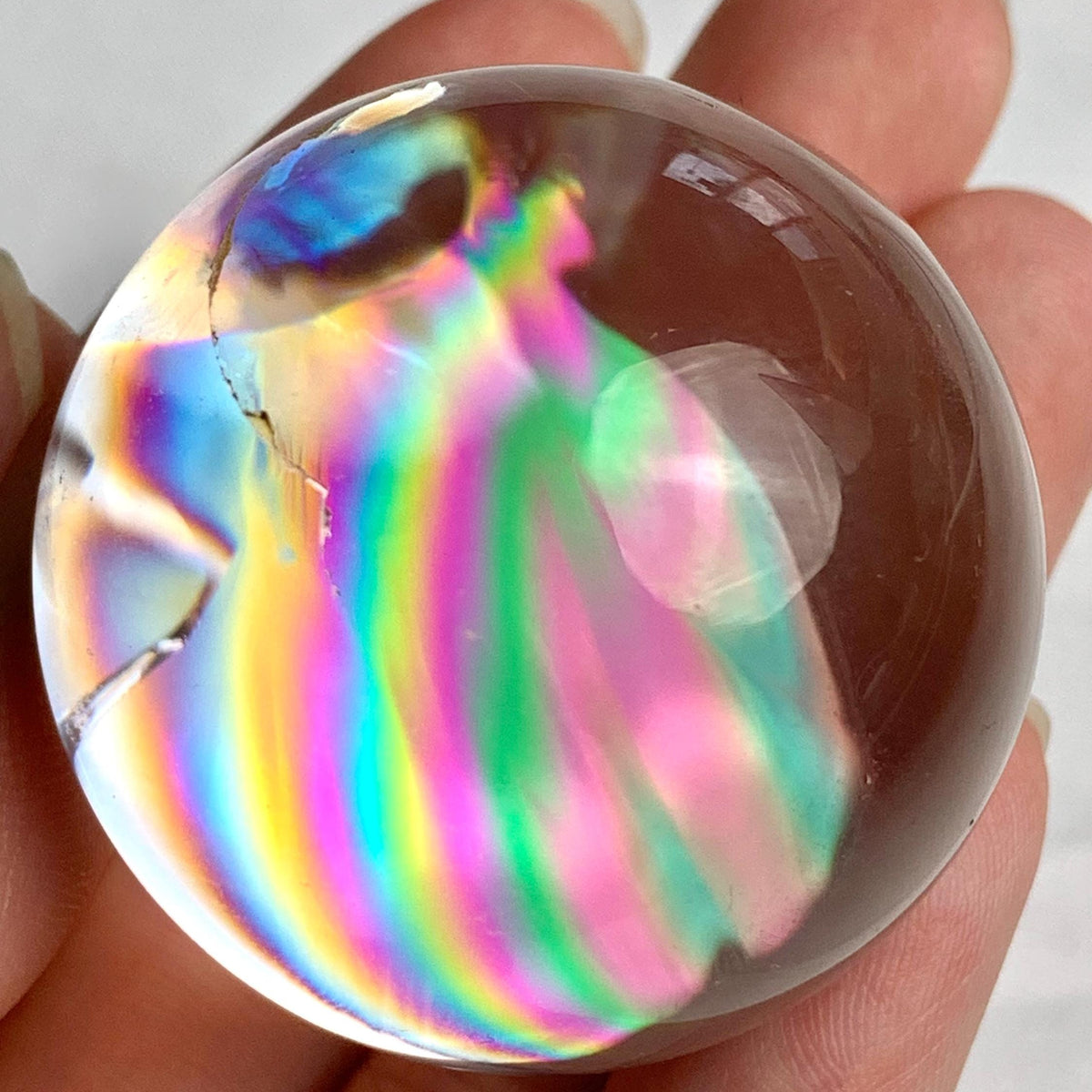 38mm clear quartz sphere displaying rare rainbow flashes inside natural fractures
