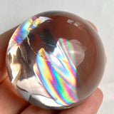 High clarity quartz crystal ball showing soft rainbow reflections