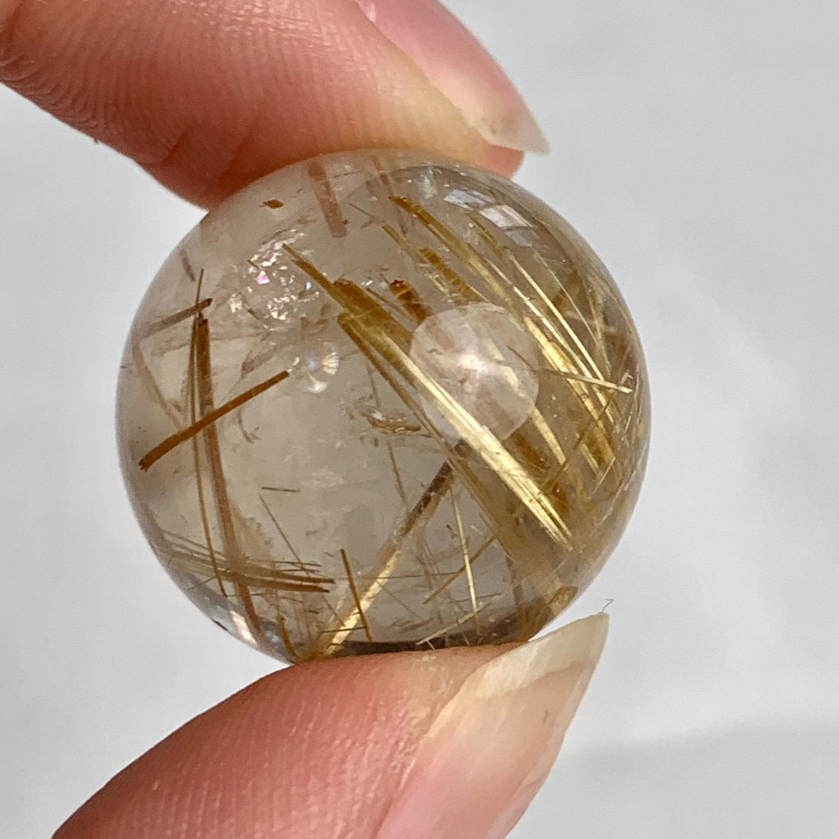 Small collector rutilated quartz sphere showing vivid golden inclusions