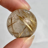 Small collector rutilated quartz sphere showing vivid golden inclusions