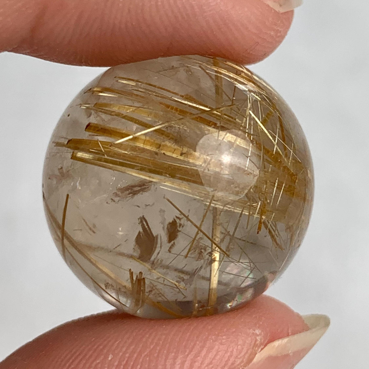 Premium rutilated quartz crystal sphere weighing 13 grams