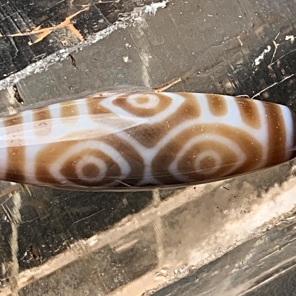 Close up of king of all dzi beads showing detailed agate bands and etched dragon eyes