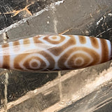 Close up of king of all dzi beads showing detailed agate bands and etched dragon eyes