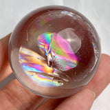 Small decorative rainbow quartz sphere displayed on crystal stand